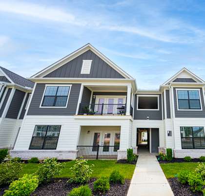 A modern two-story house with a front yard and landscaping.