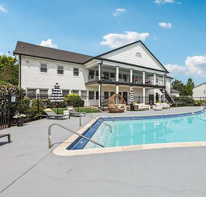 A large white house with a pool in front.