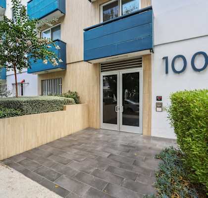 A modern building with a blue awning and the number 100 on it.