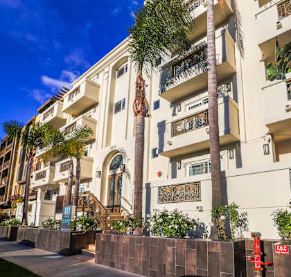 a large white building with palm trees in front of it