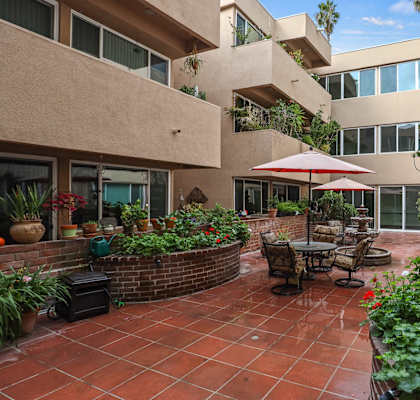 a patio with a table and chairs in a courtyard