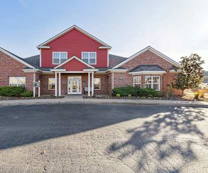 A red brick house with a white door and windows.