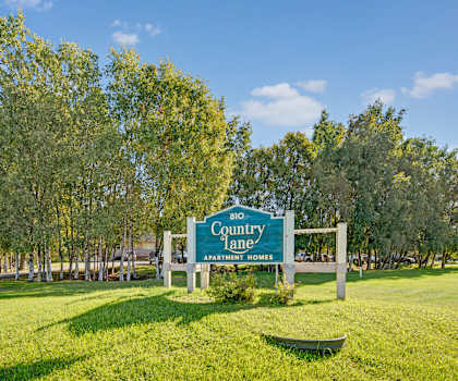 The exterior sign and building of Country Lane Apartment Homes. 