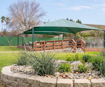 a gazebo in a park with benches and a table under it