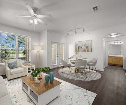 a living room and dining room with white furniture and a ceiling fan