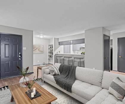 A modern living room with a grey couch and a wooden coffee table.