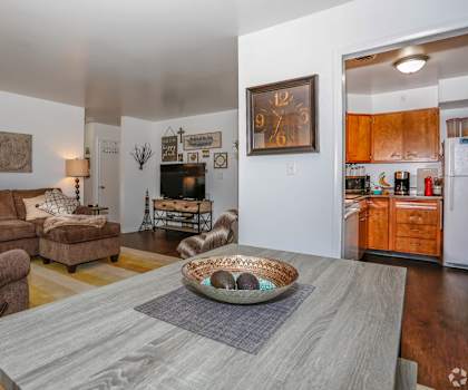 A living room with a grey coffee table and brown couches.