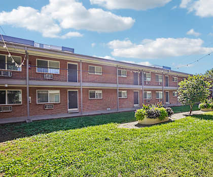 A red brick building with a green lawn in front.