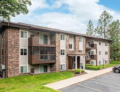 a brick apartment building with balconies and a sidewalk