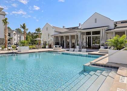 A large swimming pool in front of a white building.