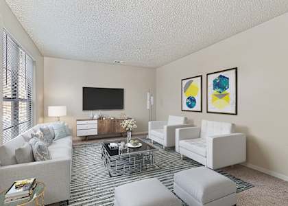 A living room with a grey sofa, a white armchair, a grey ottoman, a glass coffee table, a television, and two framed pictures on the wall.