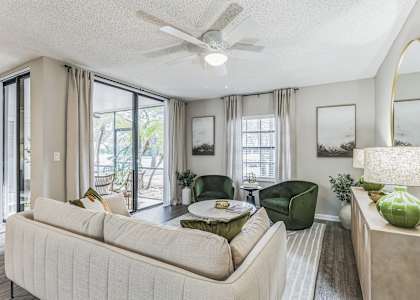 a living room with a couch and a table and a ceiling fan