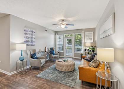 A living room with a sofa, chairs, and a rug.