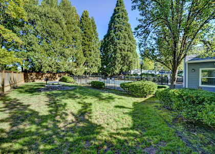 a backyard with a fence and a house and trees