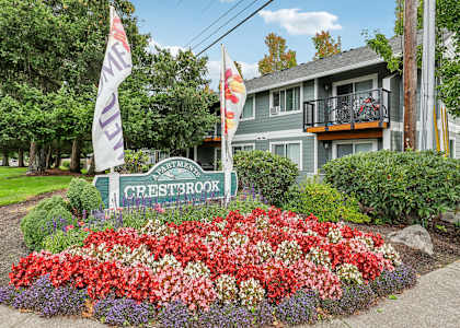 a garden with flowers and a sign in front of a house