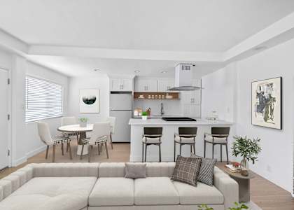 A modern living room with a grey sofa and a dining table with chairs.