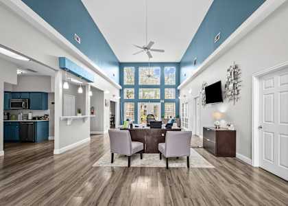 A modern kitchen with a dining area and a ceiling fan.