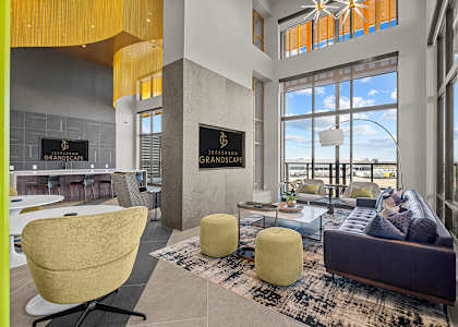 A living room with a yellow chair and a purple couch.