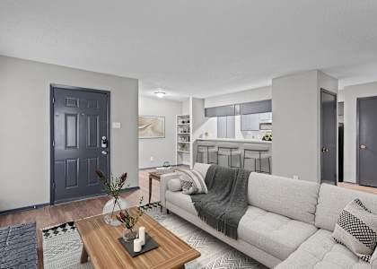A modern living room with a grey couch and a wooden coffee table.