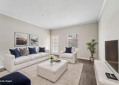A living room with a white couch, a white chair, a white coffee table, and a white rug.