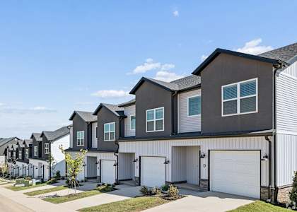 A row of modern houses with garages and driveways.