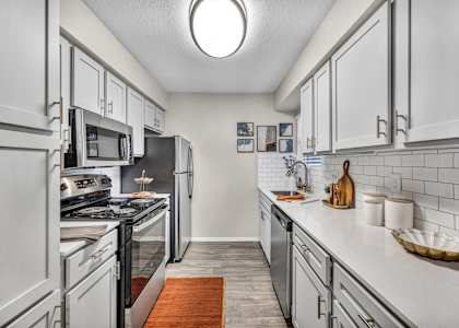 a kitchen with white cabinets and stainless steel appliances
