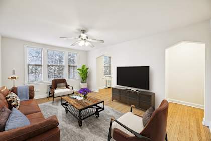 A living room with a brown couch, a coffee table, and a flat screen TV.