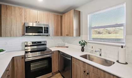 A kitchen with wooden cabinets and stainless steel appliances.