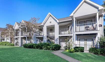 A row of townhouses with a clear blue sky above.