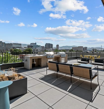 a rooftop patio with a fire pit and a view of the city