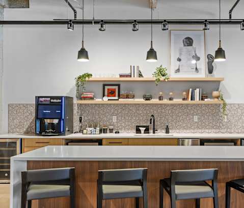 A modern kitchen with a bar area and four chairs.