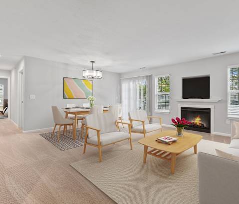 a living room with a fireplace and a dining room in the background