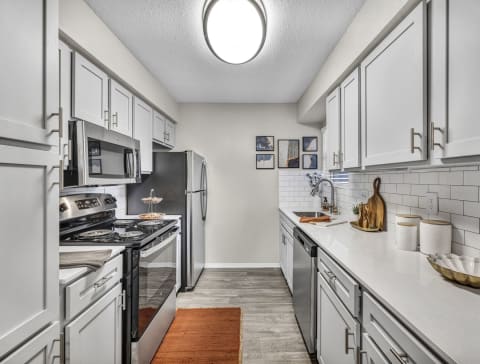 a kitchen with white cabinets and stainless steel appliances