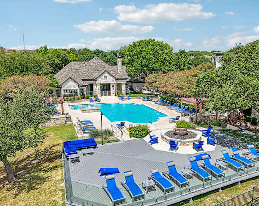A pool with blue loungers and a fountain in the middle.