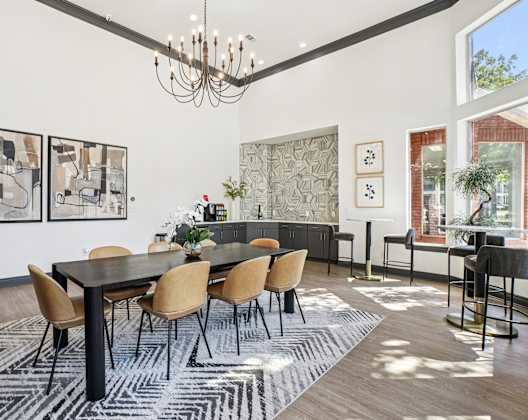 A dining room with a black table and chairs.