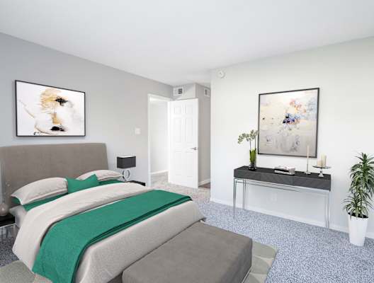 a bedroom with a bed and a desk with a green blanket