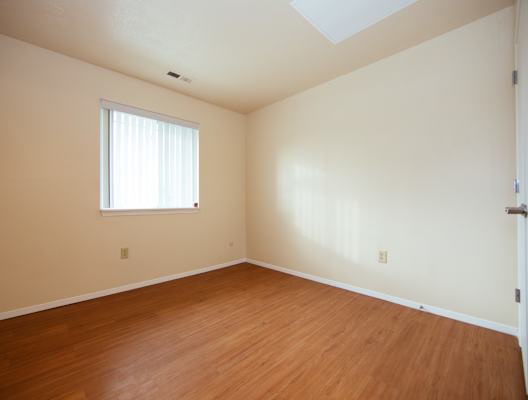 A room with a window and wooden floors.
