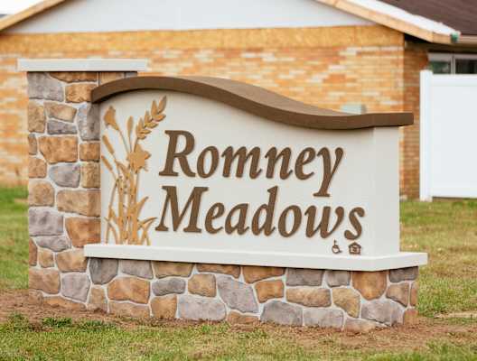 A sign that says Romney Meadows in front of a building.