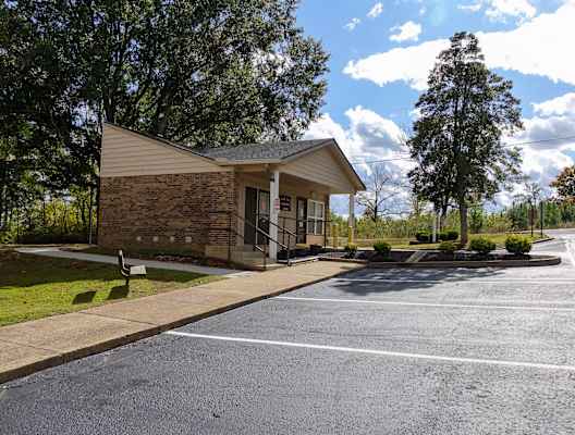 a small building with a parking lot in front of it