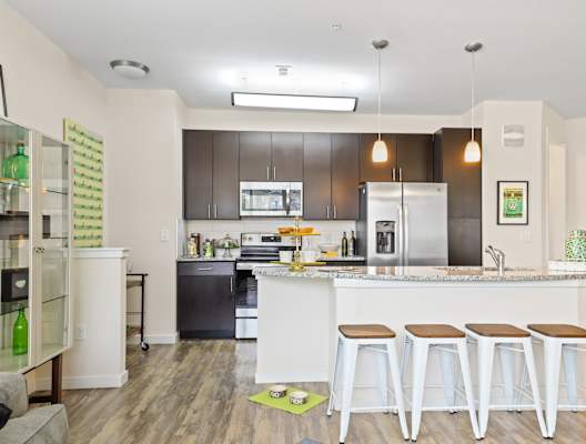 a kitchen with a large island with three stools in front of it