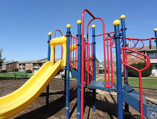 a playground at a park with a yellow slide at Caballo Crossing, Lexington, Kentucky