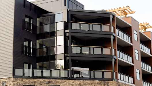 A modern multi-story building with black and brown balconies.