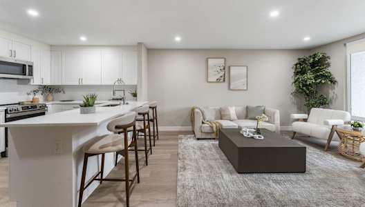 A modern kitchen with white cabinets and a large island.at Tamarack Sands Apartment Homes, Carlsbad, CA, 92008