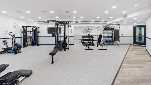 A gym with a variety of equipment including treadmills, weights, and exercise machines.at The Reserve La Mirada, La Mirada, California