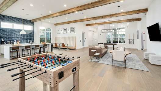 A foosball table is in the middle of a living room.