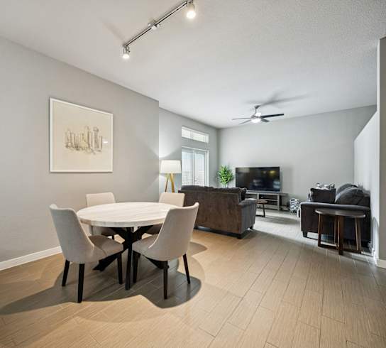 A modern dining room with a white table and chairs.