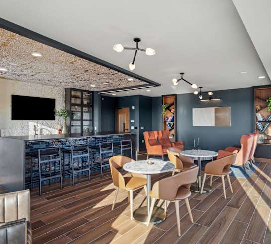 A modern dining area with a bar and a television.
