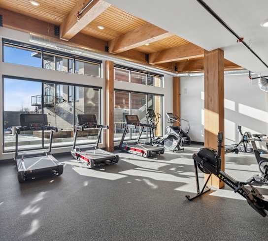 A gym with treadmills, exercise bikes and a rowing machine.