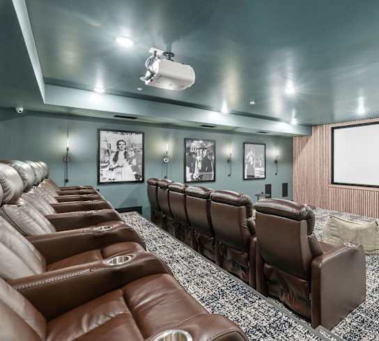 a large screening room with leather chairs and a projector screen