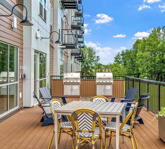 a patio with a dining table and chairs on a balcony